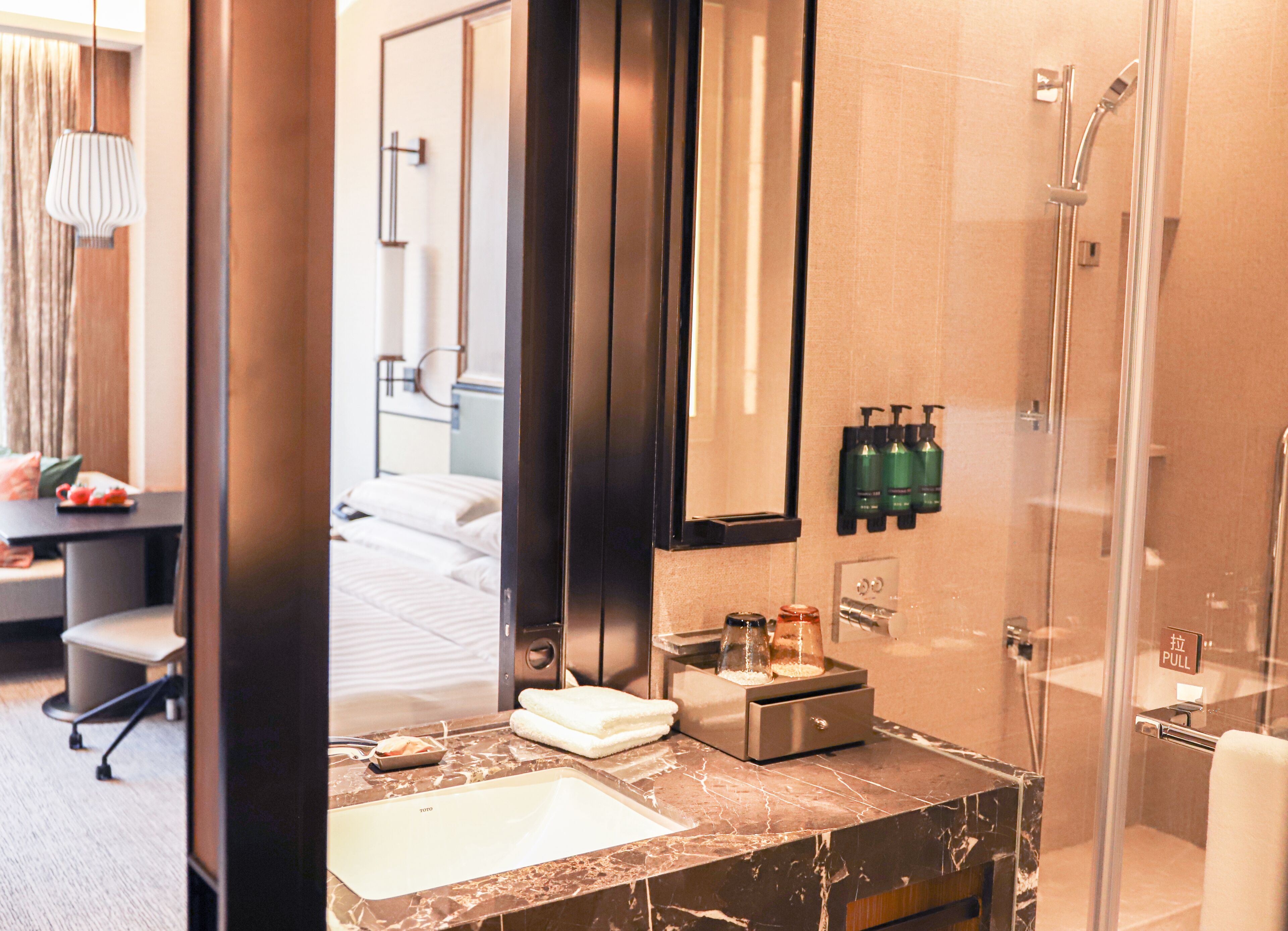 A modern bathroom with a large mirror, a sink, and a shower.