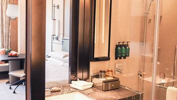 Un baño moderno con un espejo grande, un lavabo y una ducha.