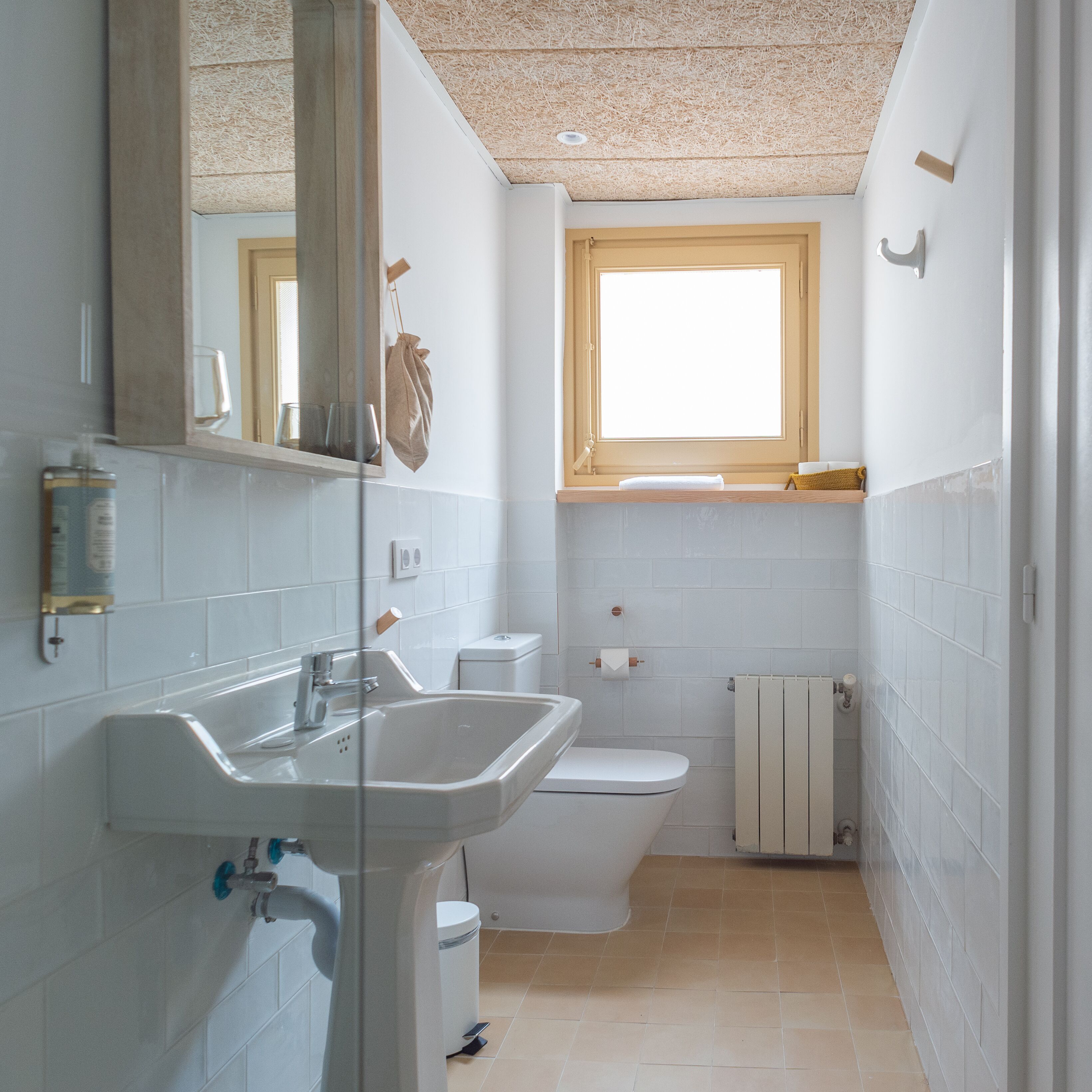 Un bagno compatto con lavandino, WC e finestra.