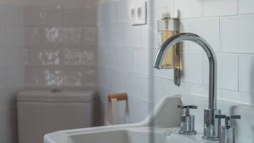 Un baño con lavamanos blanco, un espejo y un inodoro.