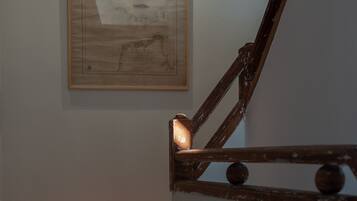 A staircase with a wooden handrail and a wall-mounted map.