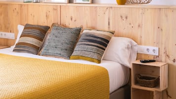 Cozy retreat with a comfortable bed, nightstand, and framed artwork.