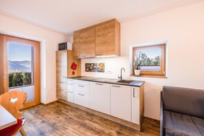 Une cuisine compacte avec des meubles en bois, un évier et une fenêtre donnant sur un beau paysage.