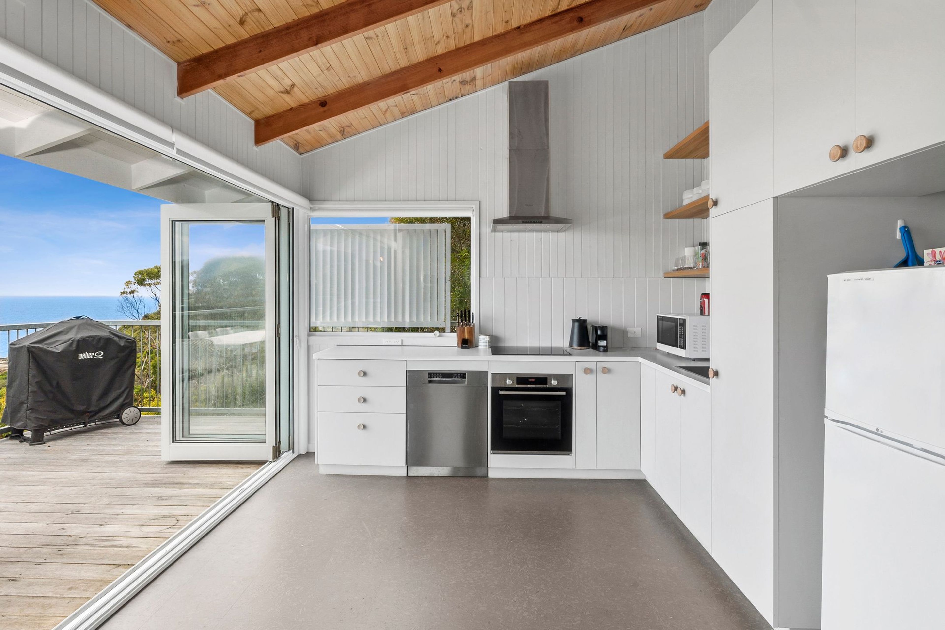 A modern kitchen with a built-in oven, dishwasher, and microwave.