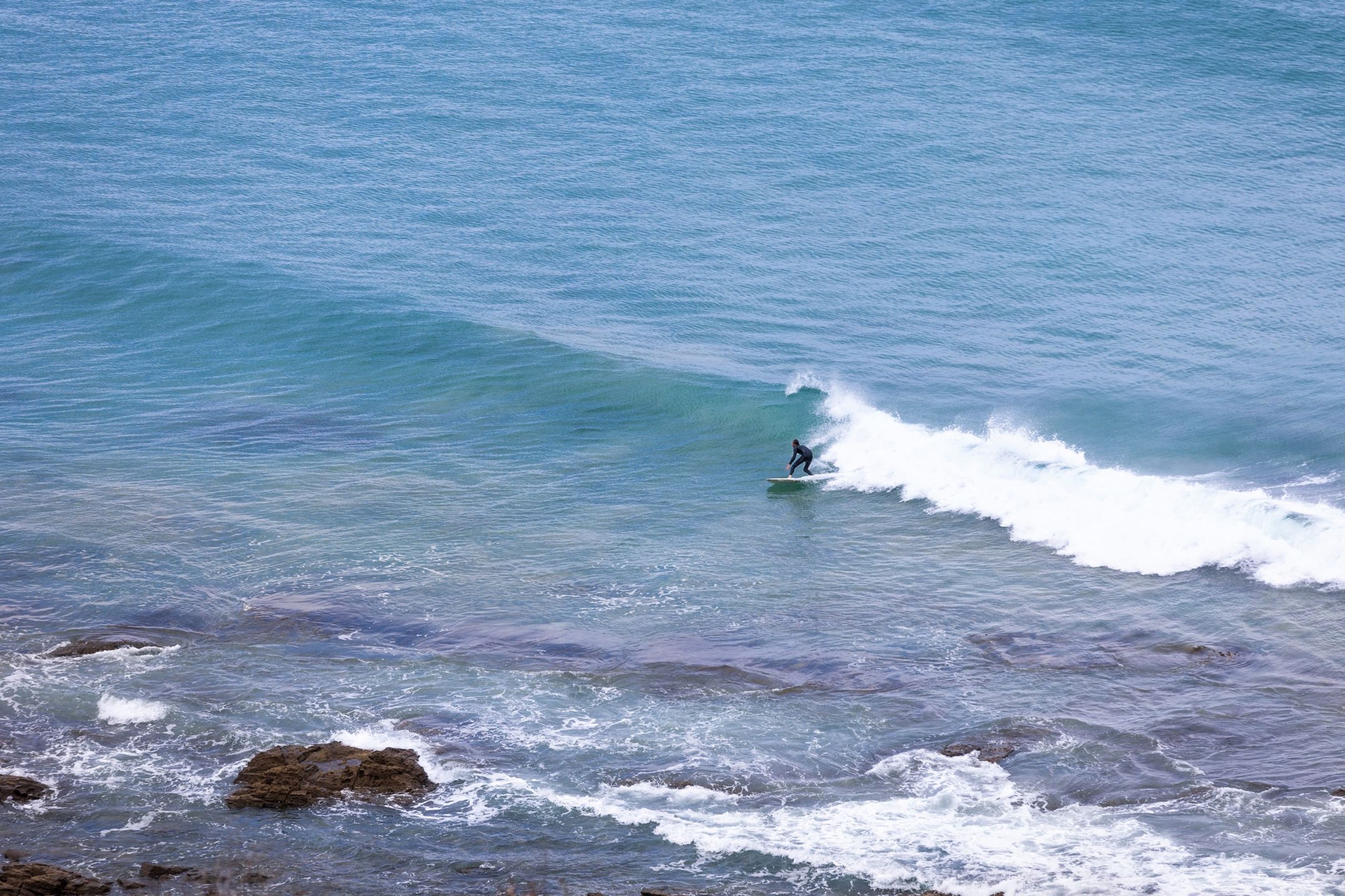 A surfer riding a wave in the ocean.