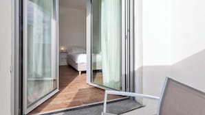 A narrow hallway with a bed and a window, leading to a bedroom. - Deluxe Apartments by Wonderful Italy (Genoa)