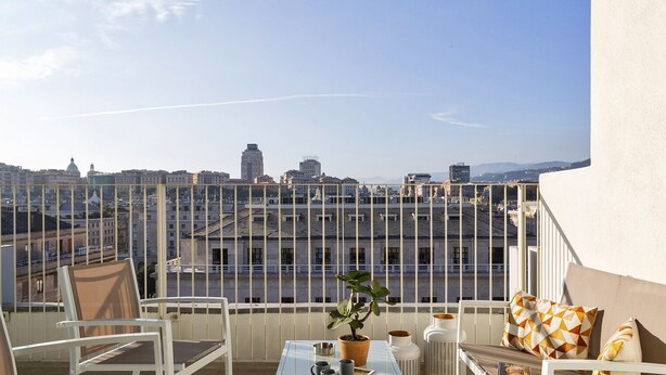 A balcony with a table, chairs, and a potted plant. - Deluxe Apartments by Wonderful Italy (Genoa)