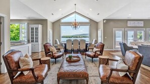 A spacious living room with a high ceiling, large windows, and a view of the outdoors. - Great Dock! Wifi, Propane Fire-Pit!  Come Visit "Dock Holiday"! (Huddleston)