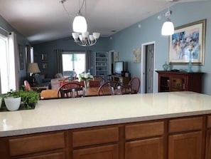 Una cocina amplia con una isla grande, armarios de madera y una zona de comedor con sillas y una mesa.