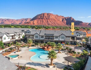 A residential area with houses, a swimming pool, and a mountain in the background. - Sunsplash Retreat at Ocotillo Springs, Sleeps 16 New Beautiful Home, near Resort Amenities (Santa Clara)