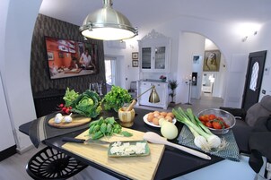 Una cucina con diverse verdure fresche, un tagliere e un coltello sul piano di lavoro.