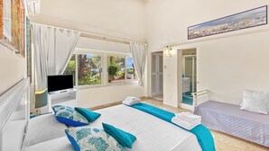 Une chambre à coucher avec un lit, une télévision, une salle de bain et une vue sur l’extérieur.