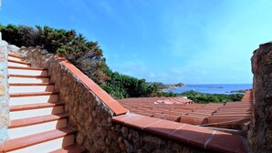 A stone staircase with terracotta steps leading to a terrace with a view of the sea. - Villa Iole (La Maddalena)