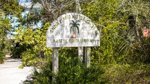 A sign for Anna Maria Historical Park with a palm tree graphic.