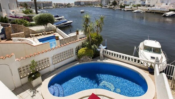 A swimming pool with a view of a marina and boats. - House with 3 bedrooms and pool overlooking the lake (Empuria Brava)