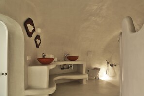Une salle de bain avec un lavabo blanc, un bidet rouge et des toilettes blanches.