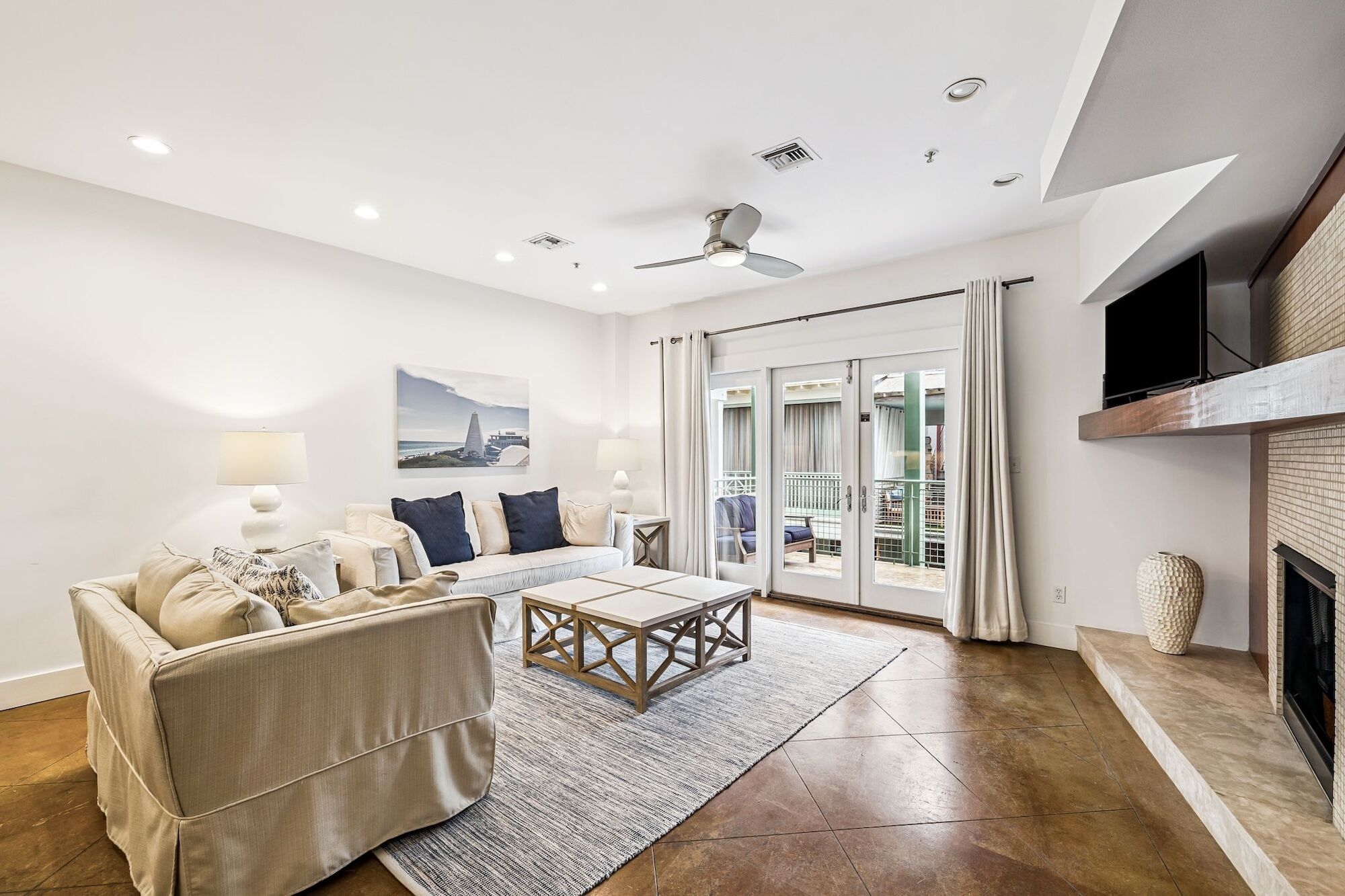 A modern living room with a sofa, coffee table, and a fireplace.