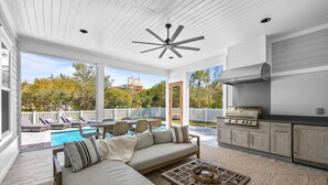 A spacious patio with a pool, outdoor seating, and a modern kitchen with a grill. - Close to the Town Square w/ Pool and LSV (Seacrest Beach)