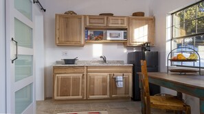 A kitchen with wooden cabinets, a microwave, a refrigerator, and a fruit basket on the counter. - Escape into serenity just minutes from the Plaza. Hot tub and sauna. (Santa Fe)