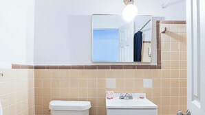 A compact bathroom with a toilet, sink, and bathtub. - Hotel O Kissimmee West - US 192 (Kissimmee)