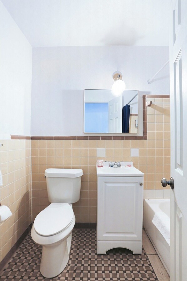 Un baño pequeño con inodoro, lavamanos y bañera.