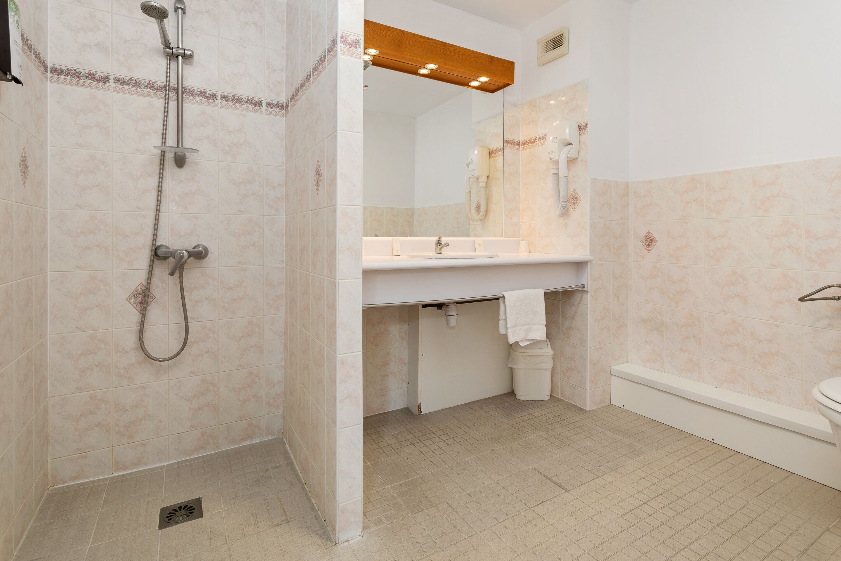 A bathroom with a shower, sink, and toilet.