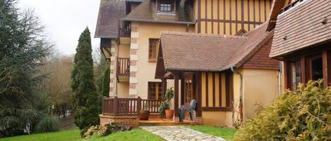 A traditional half-timbered house with a stone pathway leading to the entrance.