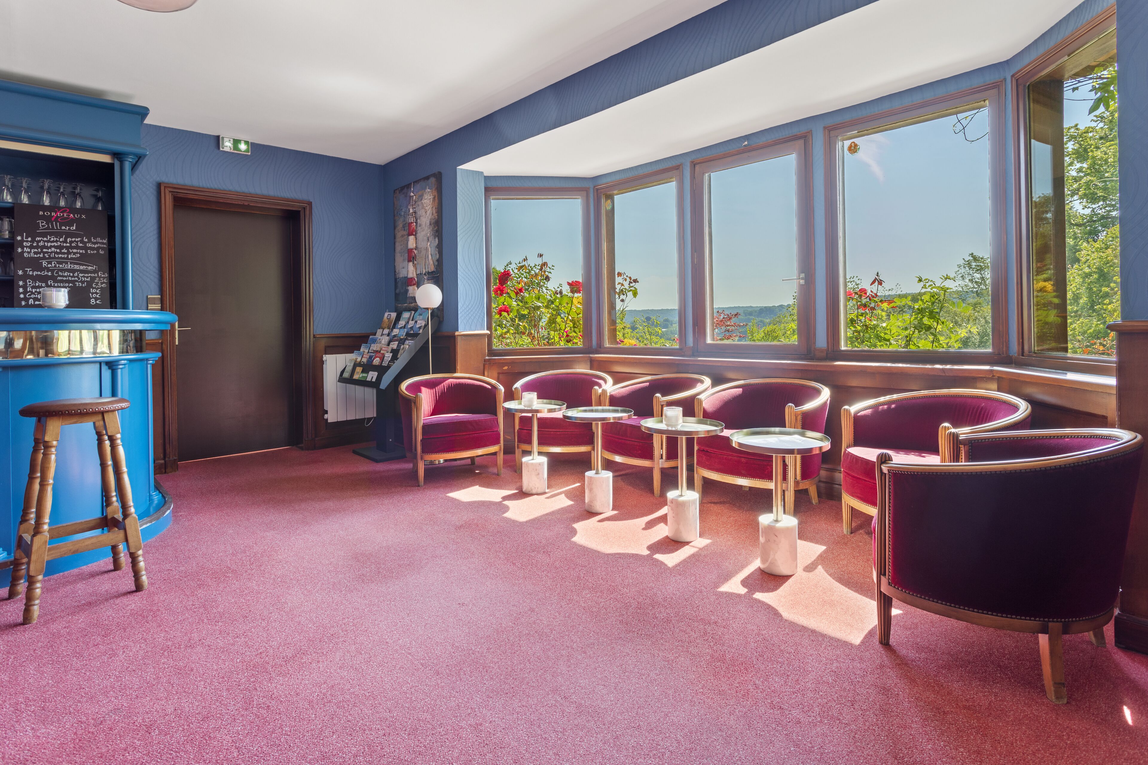 Une salle dotée d’un bar, d’un espace salon et de grandes fenêtres offrant une vue.