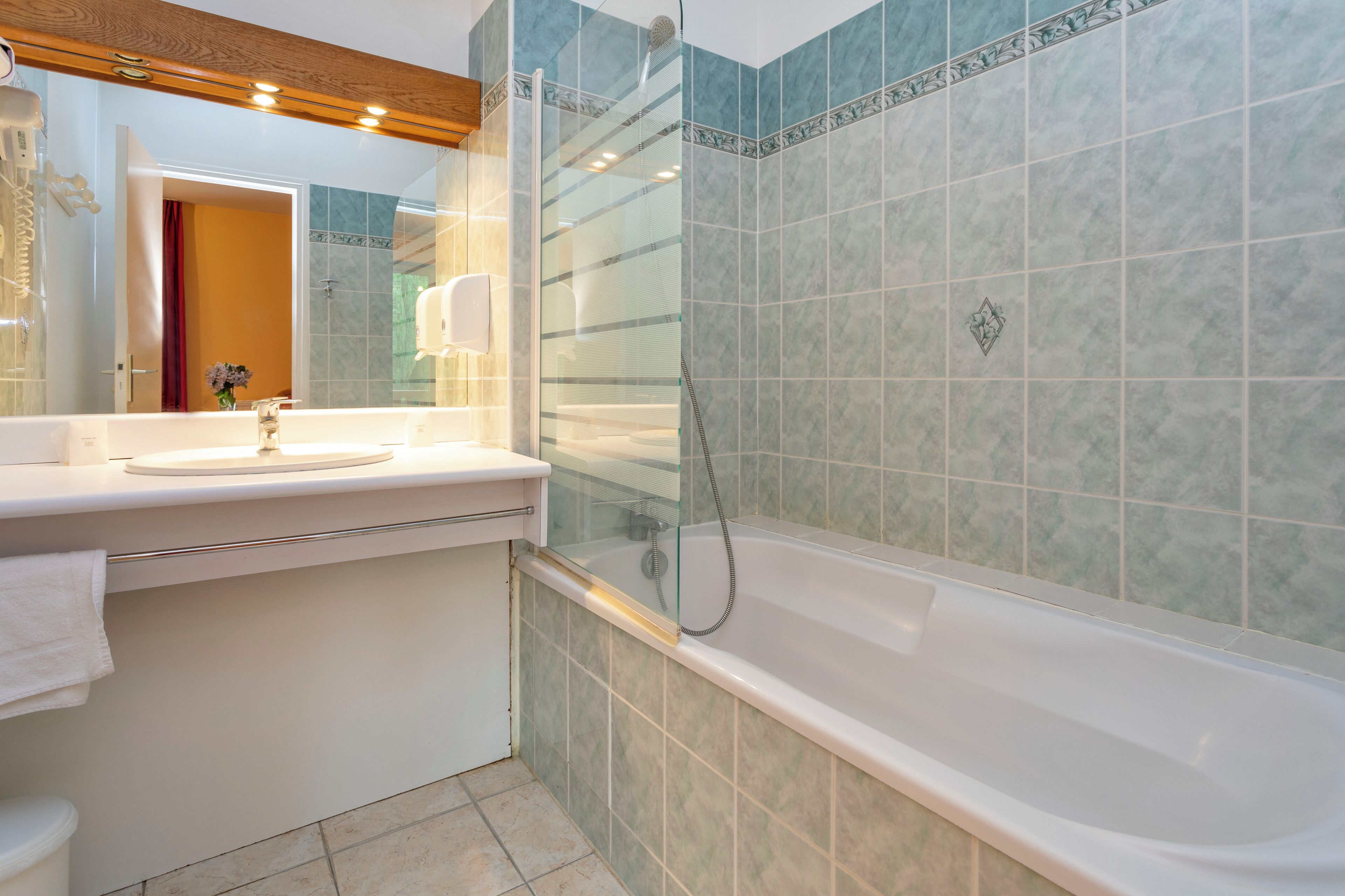 Un bagno con doccia vetrata, lavandino bianco e vasca da bagno.