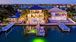 A waterfront property with a pool, dock, and multiple buildings.