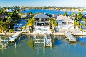 Ein Haus am Wasser mit einer großen Liegefläche, einem Steg und einem Hafen.