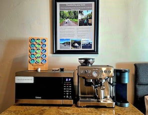 A kitchen area with a Galanz microwave, a Breville coffee maker, and a Keurig coffee maker. - Oceanfront studio see whales and dolphins (Pāhoa)
