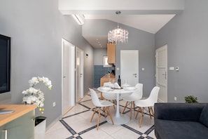 A modern living room with a dining area, grey walls, and a chandelier. - Pool Villa Sine /w Panoramic Sea View (Marina)