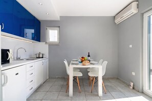 Una cocina moderna con armarios blancos, horno empotrado y ventana sobre el fregadero.