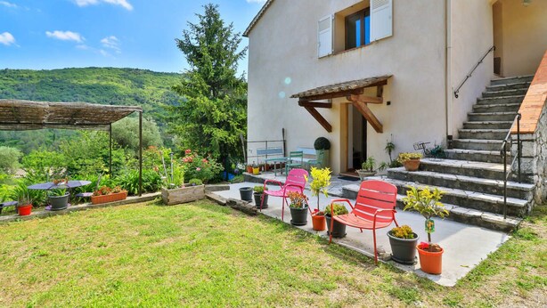 A house with a patio area, outdoor seating, and a staircase leading to the entrance. - RENTALS-06 NOELIE'S HOUSE - 300M RIVIERE 30mn NICE CANNES ANTIBES (Le Bar-sur-Loup)