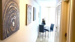 A hallway with a dining area, featuring a table and chairs, and artwork on the walls. - Ocean Golf & Country Club J&K A4 (Oasis del Sur)