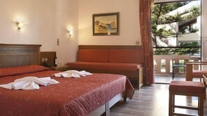 Habitación de hotel con una cama grande, un escritorio y vistas al exterior.