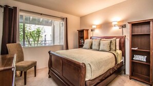 A bedroom with a wooden bed, a chair, a desk, and a bookshelf. - Great North Scottsdale Condo! (Scottsdale)