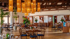 A spacious restaurant with high wooden ceilings, hanging woven light fixtures, and wooden tables and chairs. - Sun City Rota das Emoções (Camocim)