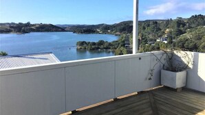 Un balcón con vista a un lago y colinas.