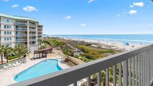 A hotel with a pool, beach access, and a view of the ocean.