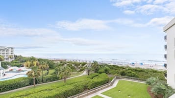 Ein Resort mit Pool, Palmen und Blick auf den Strand.