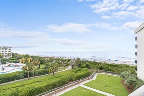 Un resort con piscina, palme e vista sulla spiaggia.