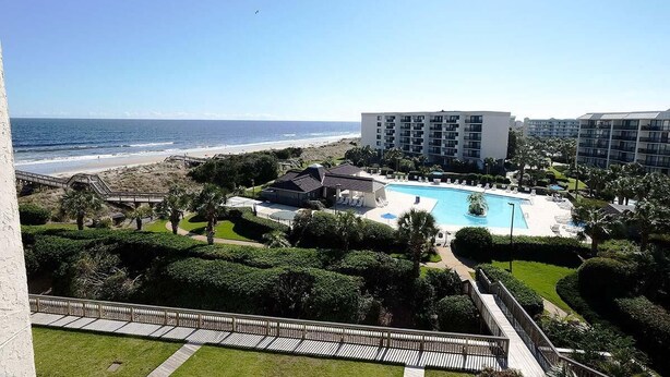 A resort with a swimming pool, beachfront, and a large building. - Coastal Oasis Inviting 3BR Condo with Resort Pool (Pawleys Island)