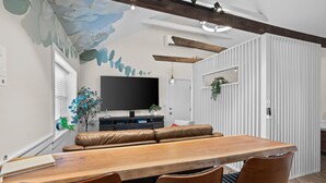 A modern dining area with a wooden table and leather chairs, a flat-screen TV, and a decorative ceiling. - Take your getaway at this magical oasis, central to "everything" (Gordonville)