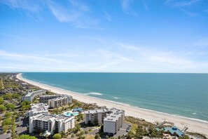 Un hotel costero con varias construcciones, playa y cielo despejado.