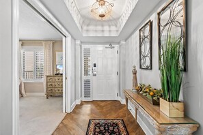 Enter a clean and minimalistic space with a console table, decorative light, and large mirror.
