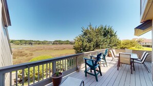 A balcony with outdoor furniture, a view of a field, and a large tree. - Lakeside Retreat Spacious 3BR 2BA Resort Amenities (Pawleys Island)