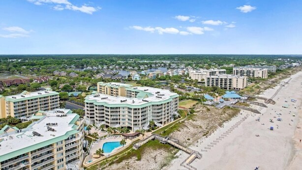 Een kusthotel met meerdere gebouwen, een strand en een zwembad.