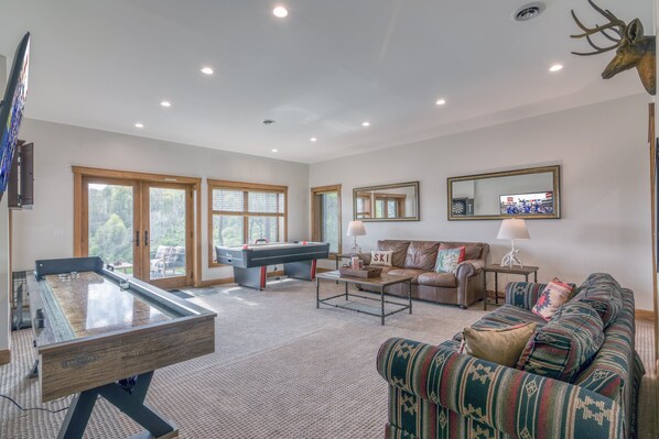 A spacious living room with a pool table, a sofa, and a coffee table.